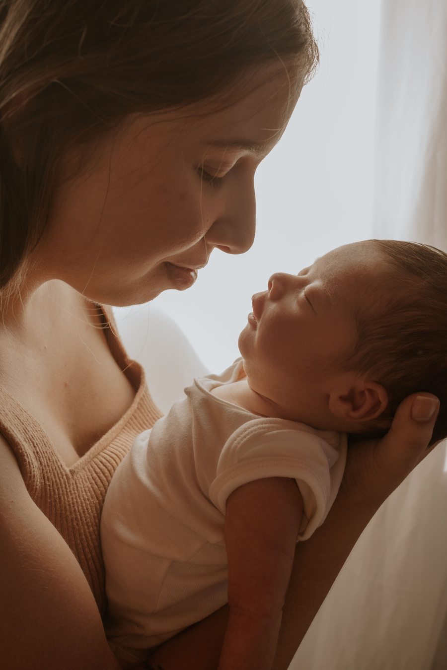 Mãe com recém-nascido em momento íntimo — cuidado pós-parto